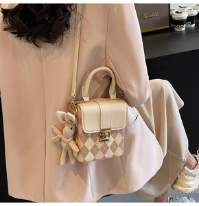 Detailed shot of quilted mini crossbody bag with plush rabbit charm and gold buckle