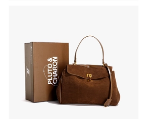 Détails d'un sac à main en daim marron foncé à côté d'une boîte cadeau de marque premium