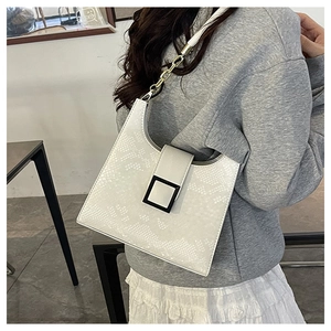 Détail du sac blanc à texture serpent avec boucle noire mate et bandoulière chaîne