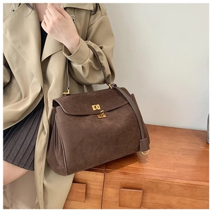 Détail d'un sac à main vintage marron café avec fermoir rotatif en métal doré