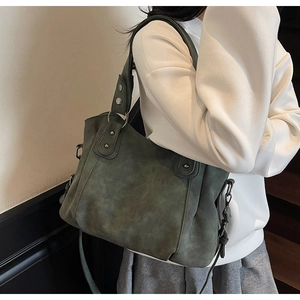 Détail du sac cabas vert foncé avec des clous argentés et une texture effet daim