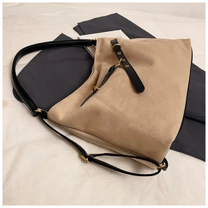 Detail view of khaki suede tote bag with black leather straps and gold metal hardware