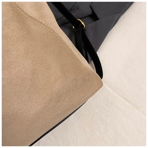 Detail of soft khaki suede fabric with black leather strap and golden metal buckle