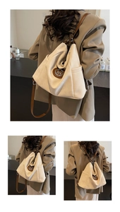 Details des cremefarbenen Rucksacks mit braunen Lederriemen und metallischem M-Logo