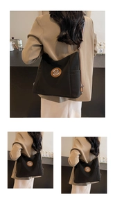 Detail der schwarzen Shopper-Tasche mit Leder-Patch, M-Logo aus Metall und Seitentaschen