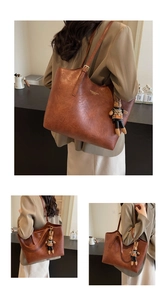 Detail of caramel brown faux leather tote bag with fashion text and rabbit charm