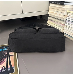 Details der schwarzen Messenger-Tasche aus Segeltuch mit zwei vorderen Pattentaschen