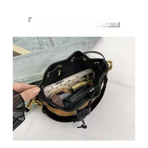 Vue intérieure du sac seau en daim marron montrant l'espace pour téléphone et cosmétiques