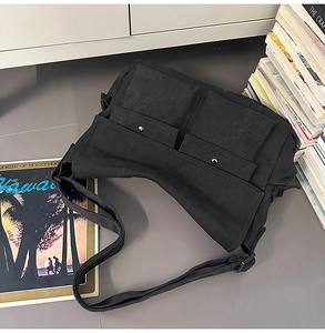 Detailansicht der schwarzen Messenger-Bag aus Canvas mit großen Taschen und Schultergurt