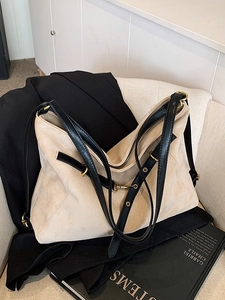 Minimalist beige suede tote bag with black contrast leather straps and golden hardware