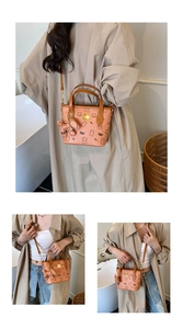 Detail der orangen Tasche mit Bärenprint, genarbtem Leder und passendem Taschenanhänger