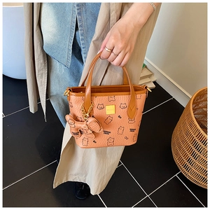 Detail einer braunen Korb-Tote-Bag mit Bärenmuster und einem kleinen Hundeanhänger