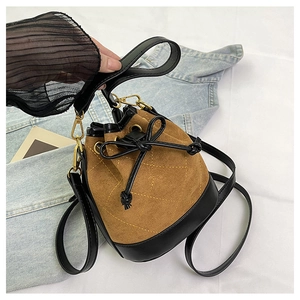 Détail du sac seau bicolore avec surpiqûres losanges jaunes et fermeture à cordon