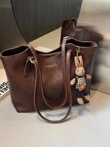 Deep brown tote bag with lychee texture, rabbit charm, and golden fashion lettering