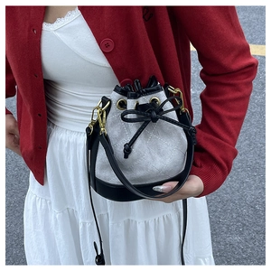Gros plan du sac seau montrant la texture en daim matelassé et le crochet doré élégant