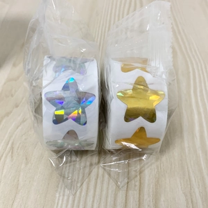 Detail of star stickers in gold and holographic silver rolls on a wooden surface