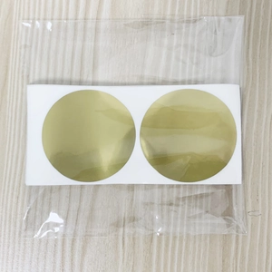 Macro detail of round gold scratch-off stickers with metallic finish in plastic packaging
