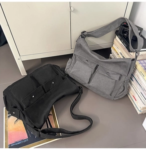 Detailansicht großer Canvas-Umhängetaschen mit zwei Vordertaschen und breiten Gurten