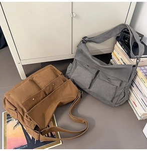 Nahaufnahme robuster Canvas-Umhängetaschen in Braun und Grau mit doppelten Vordertaschen