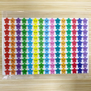 Close-up of 150 colorful cartoon star stickers with varied expressions on a wood surface