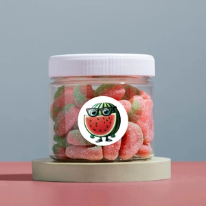 Detailed view of watermelon candy jar with cartoon stickers on light circular pedestal