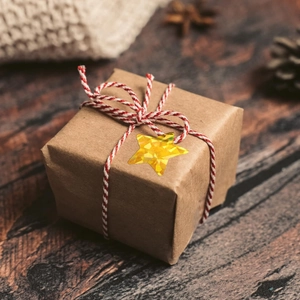 Holographic laser star sticker on a kraft gift box with red and white twine cord
