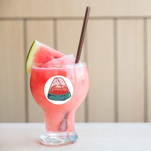Detail of round watermelon sticker with star and moon motif on a summer glass