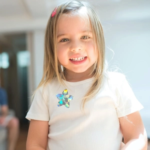 Close-up of holographic star-shaped stickers with rainbow effect on a white t-shirt