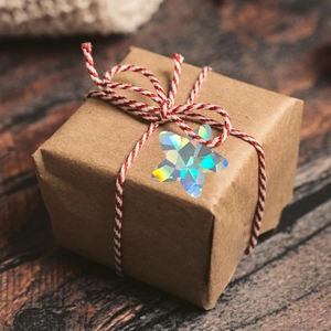 Holographic star sticker used as decoration on a brown gift box with cotton string