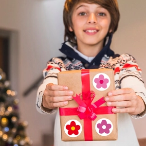 Child presenting gift box with red flower reward stickers for festive decoration