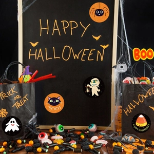 Gros plan d'autocollants d'Halloween sur sacs cadeaux noirs avec motifs fantômes et araignées