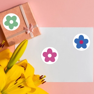 Close-up of colorful flower reward stickers on pink gift boxes and white cards