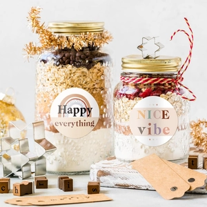 Detail view of mason jars with decorative reward stickers and gold lids for gift packaging