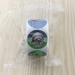 Close-up of rolled animal motivational stickers with real photos and encouraging text