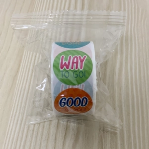 Detail of colorful round reward stickers in a roll with motivational English text