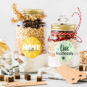 Close-up of decorative stickers on DIY glass jars with motivational quotes for gifts