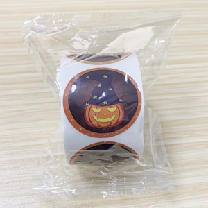 Close-up of Halloween pumpkin sticker roll with wizard hat design in plastic packaging