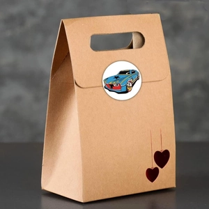 Brown kraft paper gift bag with handles and a colorful cartoon race car sticker on top