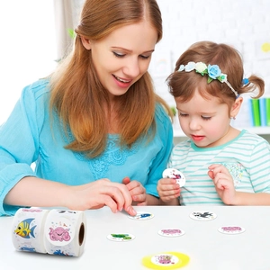 Close-up of ocean animal roll stickers being used by mother and child at home