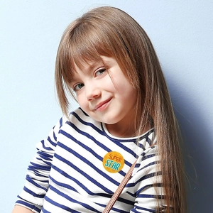 Close-up of a Super Star reward sticker on a child's blue and white striped shirt