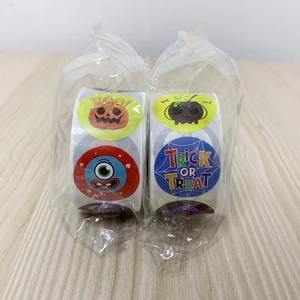 Close-up of Halloween sticker rolls in transparent packaging on a wooden surface