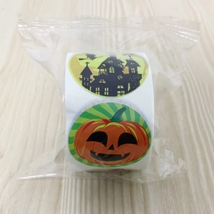 Macro view of Halloween stickers roll featuring pumpkin and bat motifs on wood background