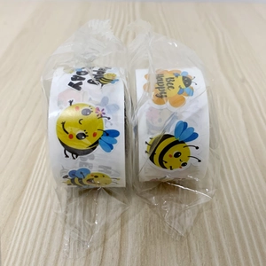 Close-up of cute cartoon bee stickers on rolls with Bee Happy and flower patterns