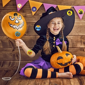 Detail of Halloween stickers with pumpkin and ghost motifs on a wooden background