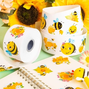 Close-up of cute cartoon bee and sunflower stickers on a notebook and paper roll