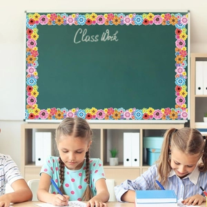 Nahaufnahme bunter Blumen-Bordüren-Aufkleber auf einer Schultafel mit glücklichen Kindern