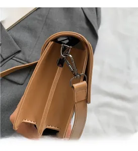 Vista dettagliata della borsa in pelle marrone con gancio in metallo grigio scuro