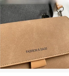 Dettaglio della texture in pelle scamosciata marrone chiaro con logo FASHION & BAGS