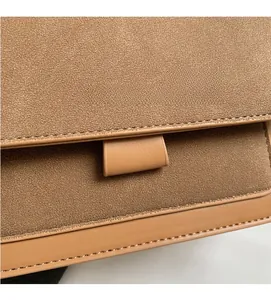 Dettaglio della texture in pelle scamosciata marrone con cuciture precise e logo moda