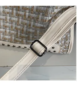 Detail des verstellbaren cremefarbenen Lederriemens und Tweedstoffs der Tragetasche